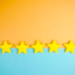 Bright yellow stars arranged on a vivid orange and blue background with copy space.